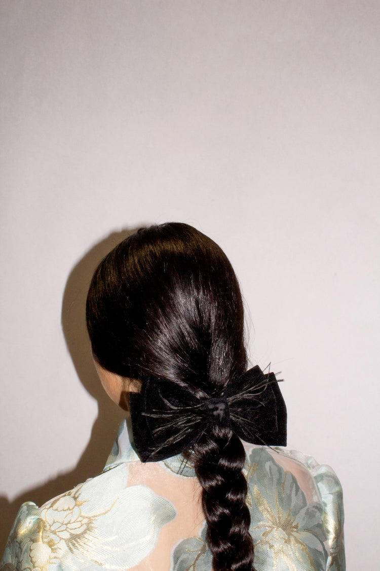 Lazo de terciopelo negro con plumas